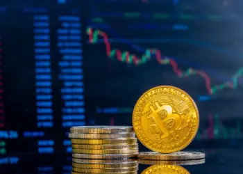 close up of golden bitcoins on a dark reflective