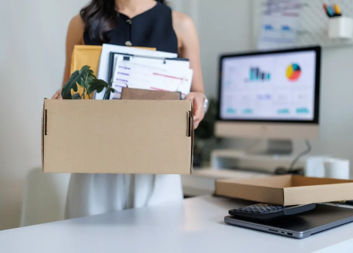 office worker carrying cardboard box with belongin