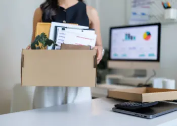 office worker carrying cardboard box with belongin