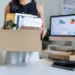 office worker carrying cardboard box with belongin