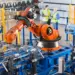 robotic arm assembly line with workers in factory