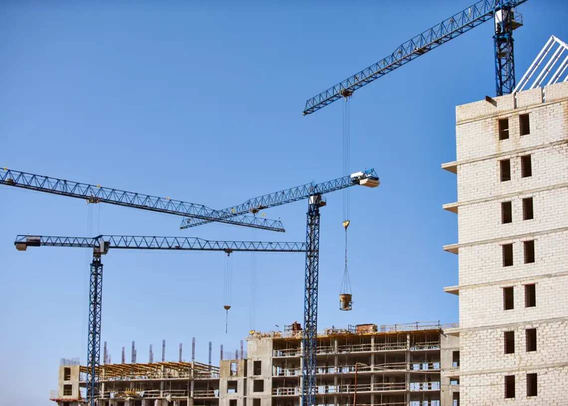 construction site with cranes against blue sky
