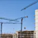 construction site with cranes against blue sky