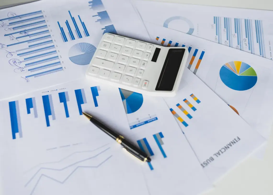 financial documents and calculator on white desk