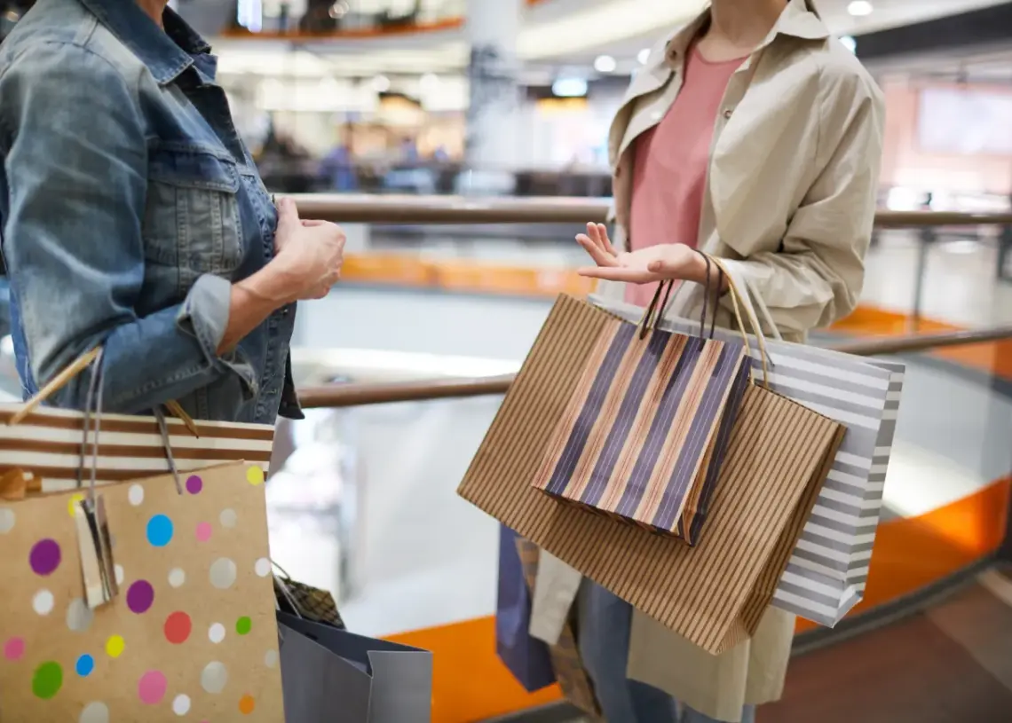 women discussing purchases in shopping mall