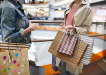 women discussing purchases in shopping mall