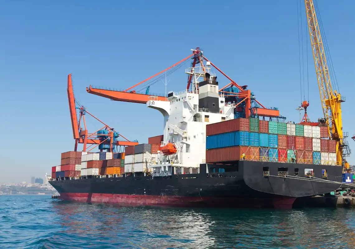 cargo ship docked at port under blue sky