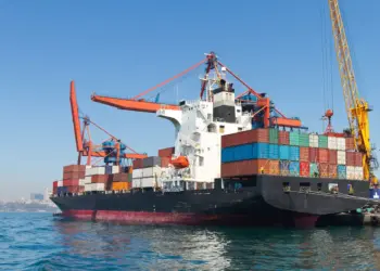 cargo ship docked at port under blue sky