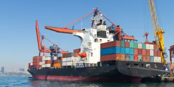 cargo ship docked at port under blue sky