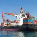 cargo ship docked at port under blue sky