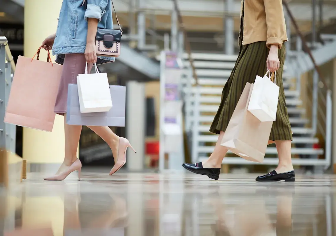 women carry shopping bags walking through shopping