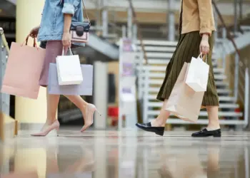 women carry shopping bags walking through shopping
