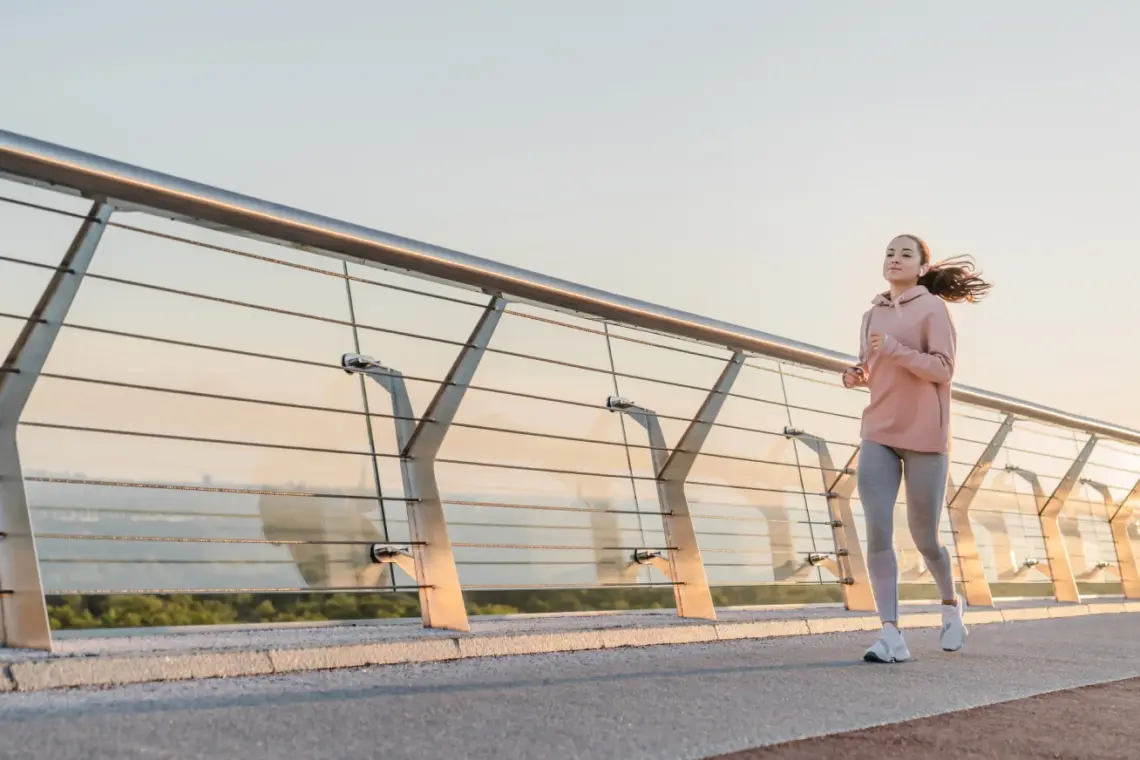 teen running on bridge during sunrise