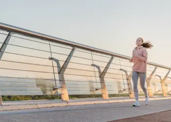teen running on bridge during sunrise