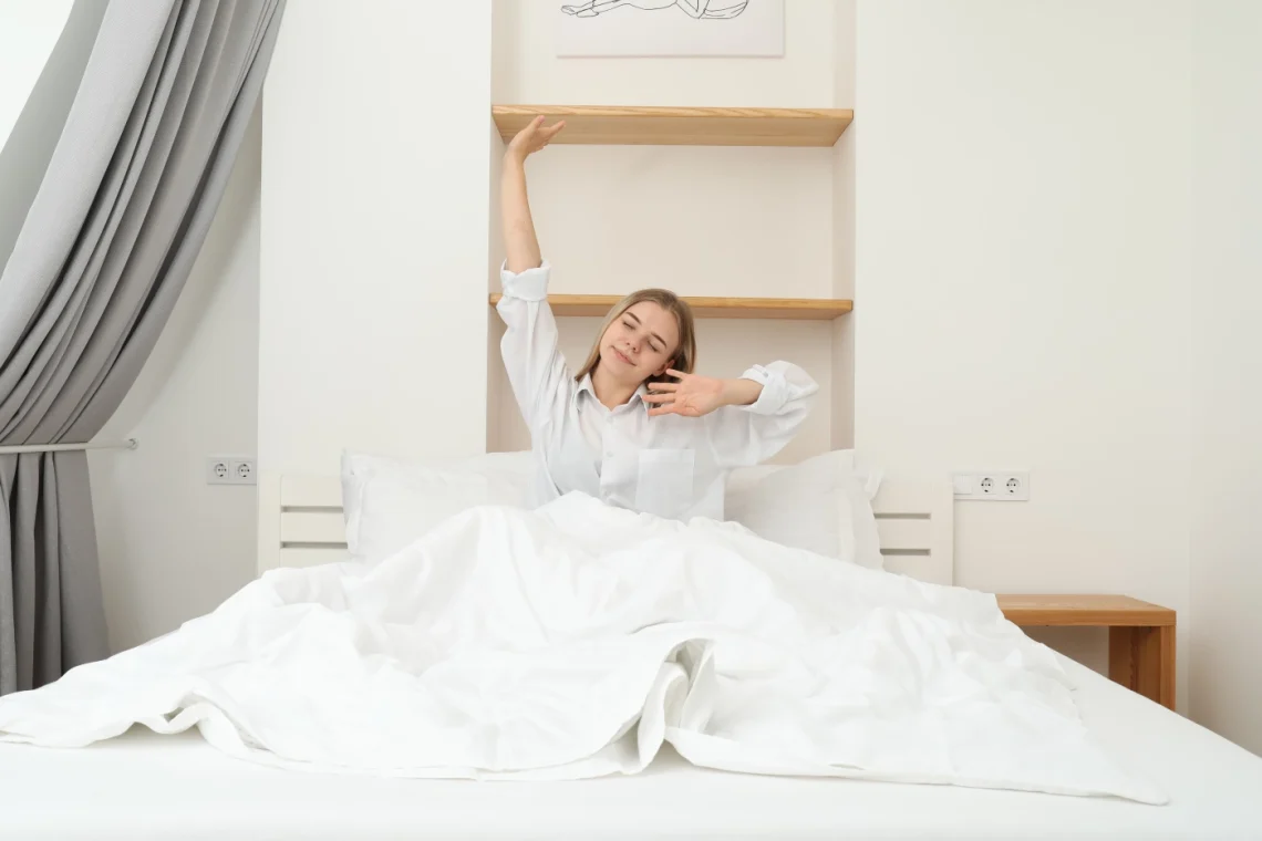 woman waking up and stretching in bed