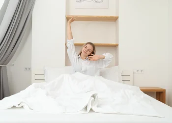 woman waking up and stretching in bed
