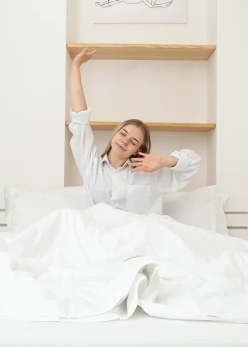 woman waking up and stretching in bed