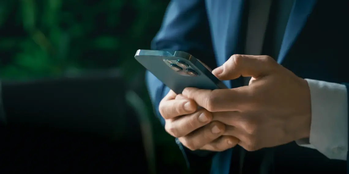 man in suit using smartphone in office