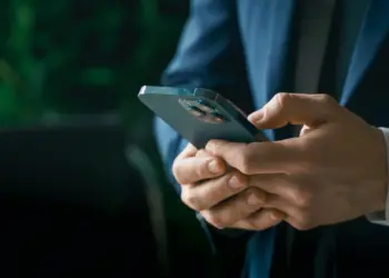 man in suit using smartphone in office