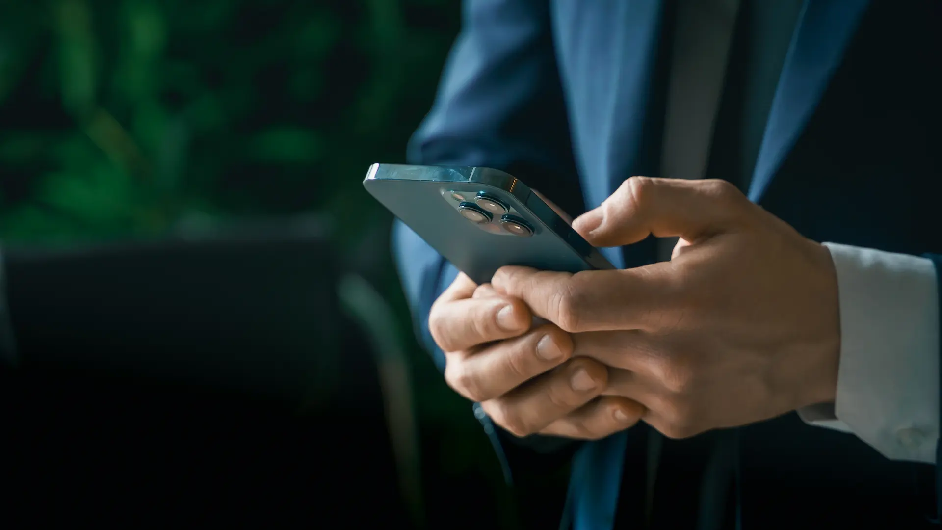 man in suit using smartphone in office