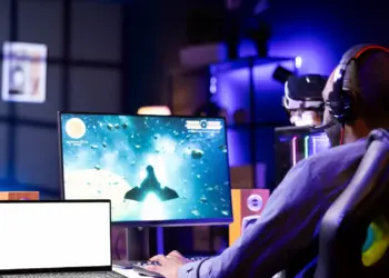man playing video game wearing headphones at home