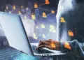 side view and close up of hacker hand using laptop