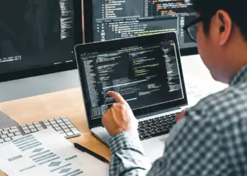 software developer working at desk with multiple