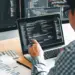 software developer working at desk with multiple