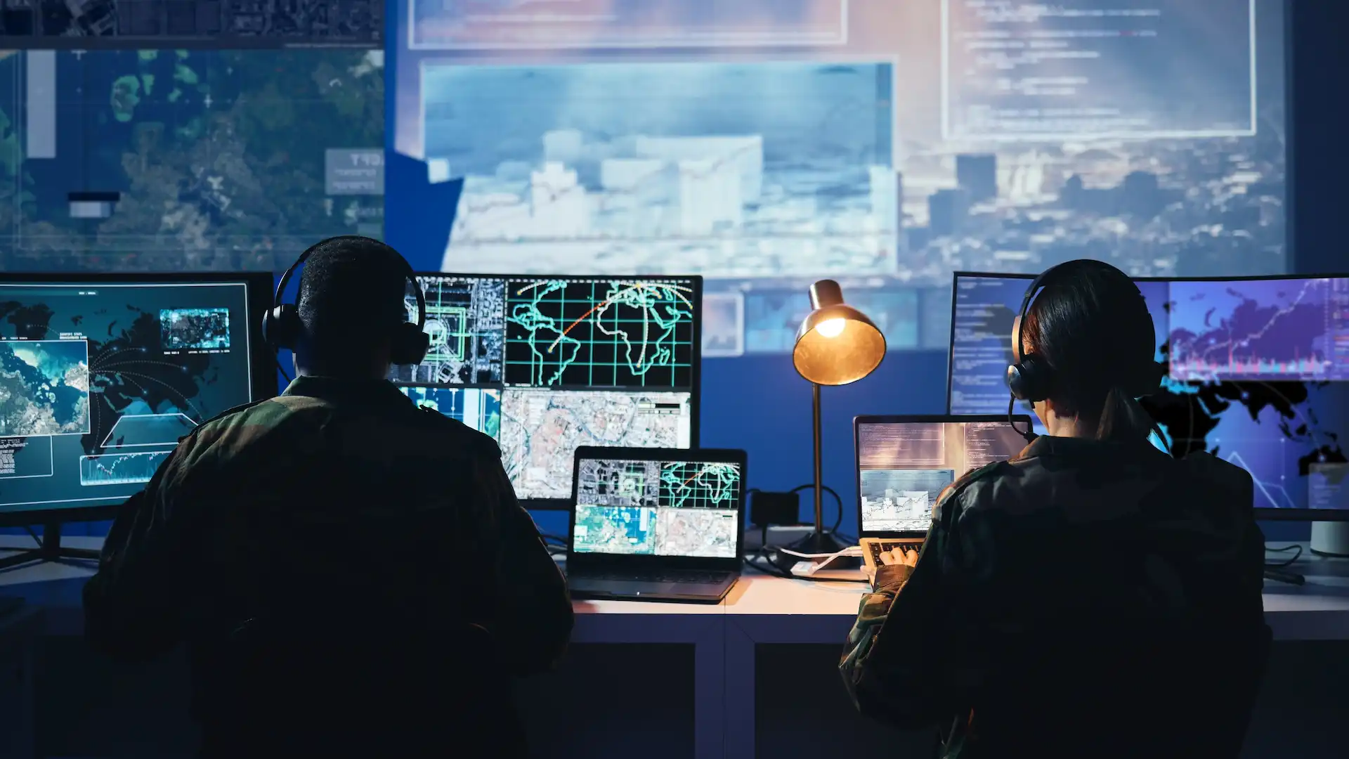 analysts work on computers in dark urban workplace