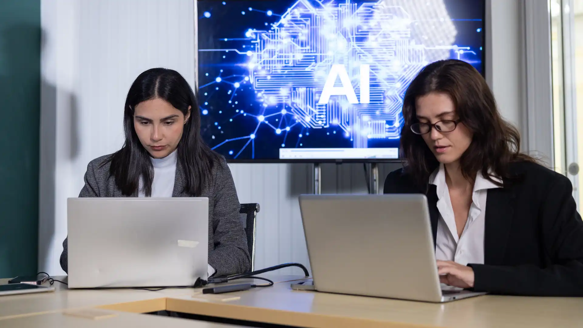 women using laptops in modern workplace with ai